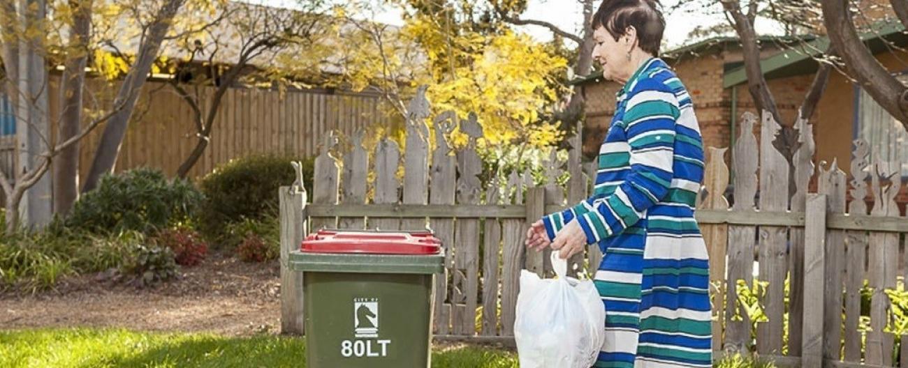 Image of lady putting out rubbish