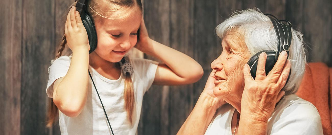 Child and grandparent listening to music