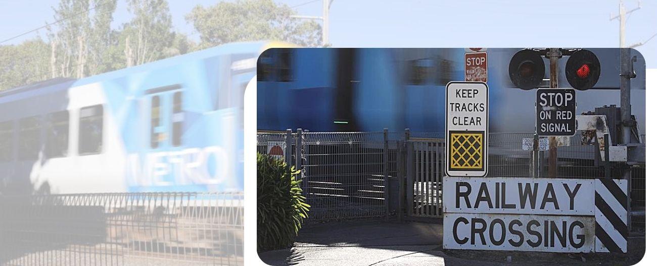 Train crossing a level crossing with gates down and lights flashing