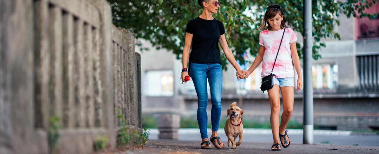 Young teenager walking with parent and dog