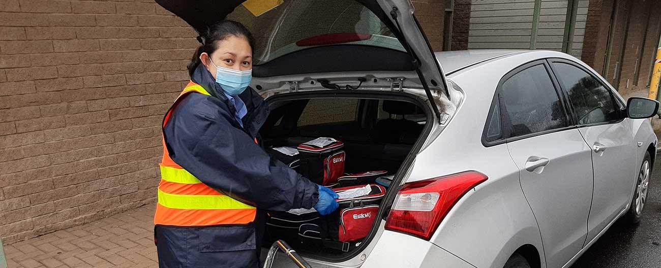 Woman making delivery from back of car