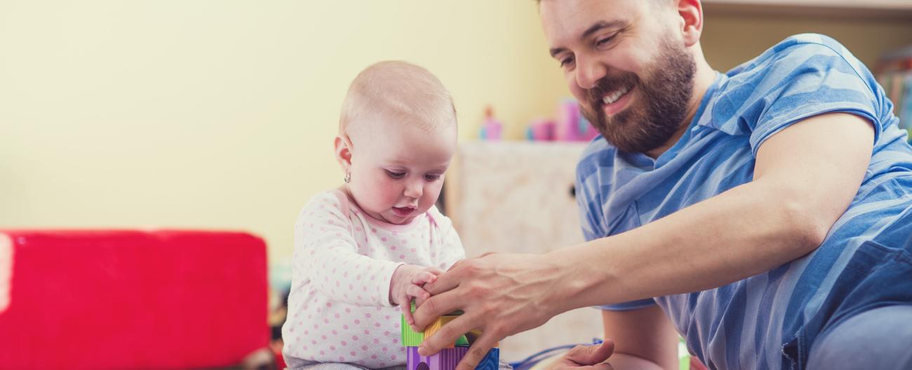 Father on floor playing with young child