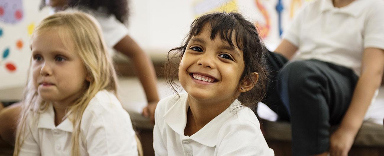 Young children siting on the mat in classroom