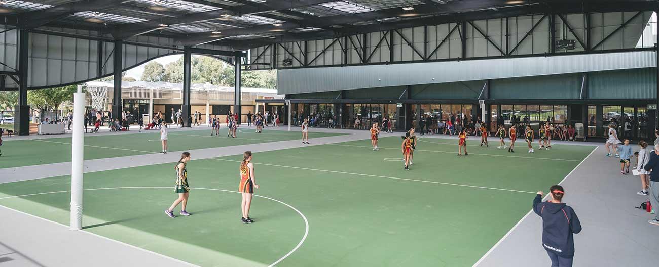 Sportlink stadium showing undercover netball courts with a match