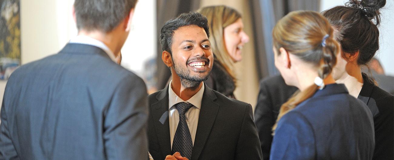 A young Asian bussineman taking to a group of people