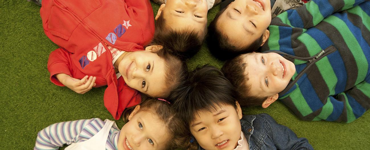 A group of multicultural children laying on the ground