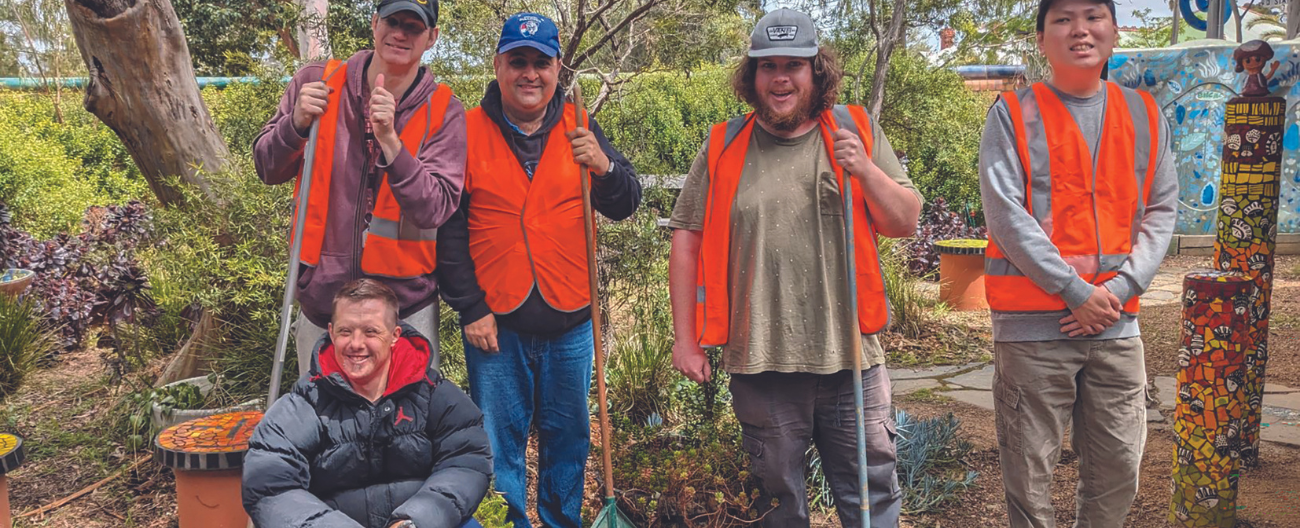 five male volunteers in orange vests pose for the camera