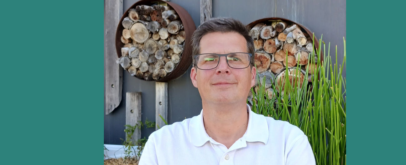 Rob in front of plants and bee hotel